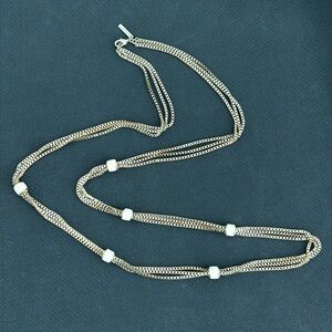 Mythologie long gold tone necklace w/ cream/white beads